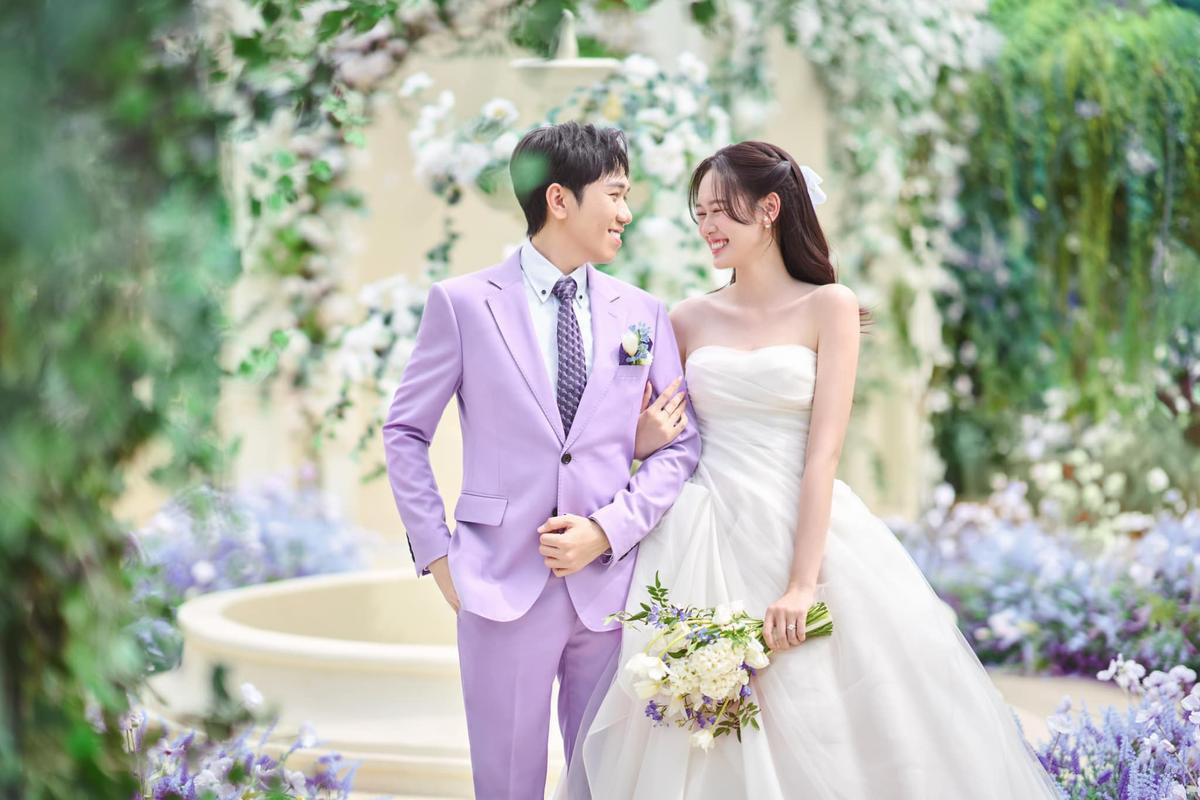 Có thể là hình ảnh về 2 người, bộ vét, hoa cát tường và đám cưới