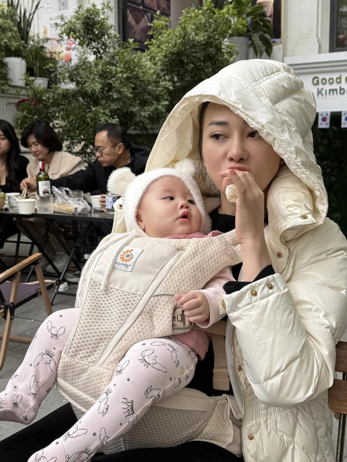 Có thể là hình ảnh về 2 người, em bé, áo phao lông vũ và áo dạ khuy sừng