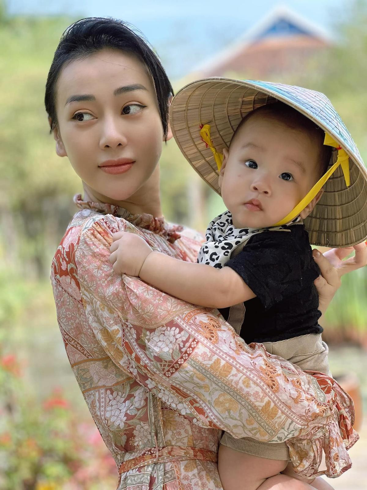 Có thể là hình ảnh về 1 người, em bé và mũ