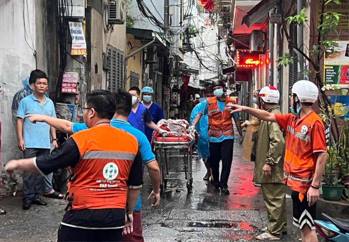 Lực lượng chức năng đưa các nạn nhân ra khỏi hiện trường vụ cháy. Ảnh: Báo CAND