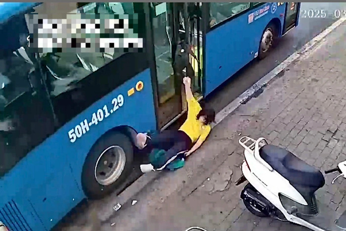 Nữ sinh bị kéo ngã xuống đường, nằm cạnh bánh xe buýt.