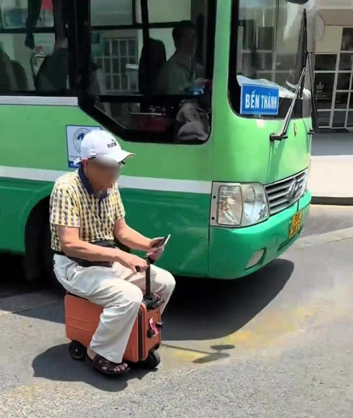 Người đàn ông ngồi trên vali điện, chạy giữa đường. (Ảnh từ Tuổi Trẻ Online)
