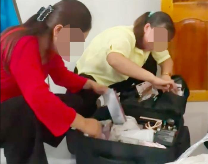 Người nhà chú rể lục đồ của thợ trang điểm để tìm kiếm số tiền 20 triệu đồng bị mất. Ảnh cắt từ clip