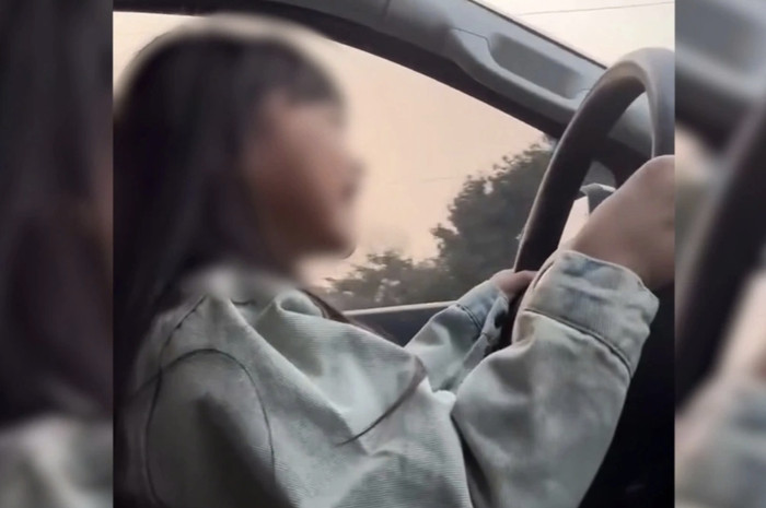 Video bé gái được bố cho ngồi vào ghế lái, tay cầm vô lăng lái ô tô với tốc độ 60 km/h gây xôn xao mạng xã hội. (Ảnh cắt từ video)
