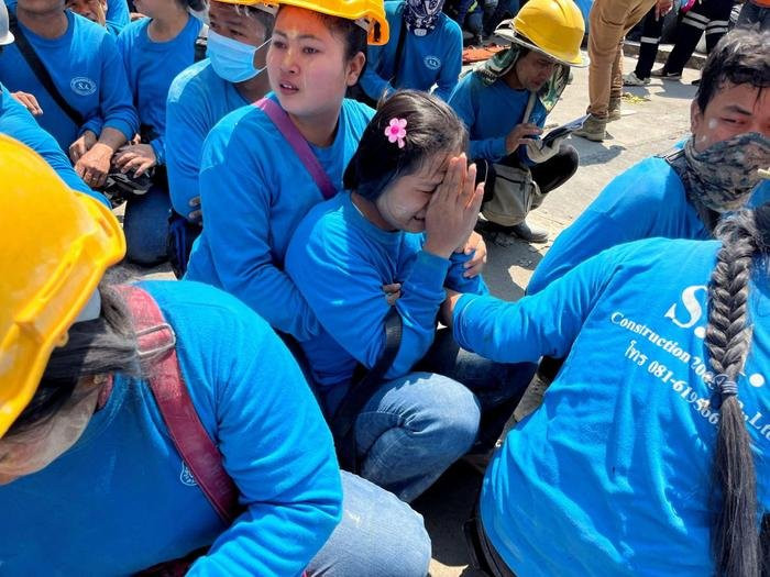 Những người may mắn thoát nạn không kìm được nước mắt khi chứng kiến cảnh tượng kinh hoàng. Ảnh: AFP