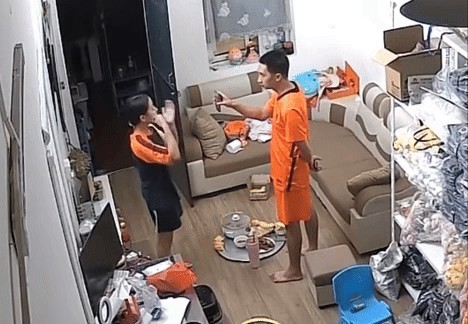 Sau khi bị chú tịch thu điện thoại, bé gái nhìn bố qua điện thoại và dùng ngôn ngữ ký hiệu để trò chuyện, đồng thời đưa tay đòi lại điện thoại từ chú. Ảnh cắt từ clip/Nguồn: Thắng Vũ