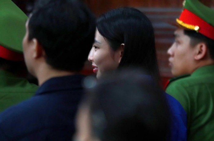 Hoa hậu Thuỳ Tiên hiếm hoi nở nụ cười suốt phiên toà. Nguồn ảnh: báo Thanh Niên