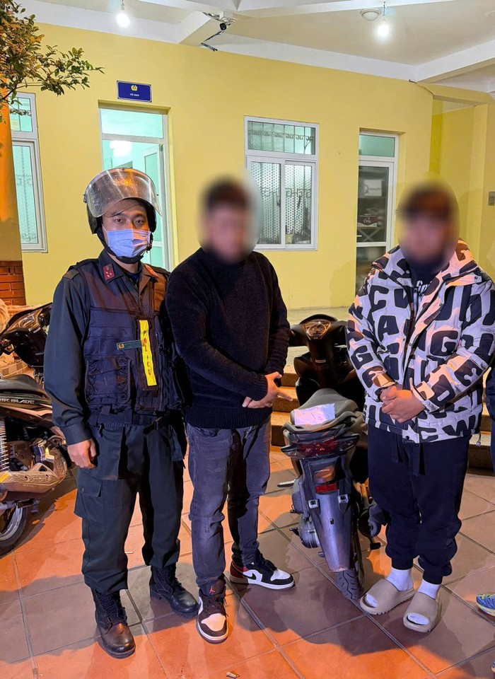 2 đối tượng bên cạnh tang vật. Ảnh: Công an TP Hà Nội