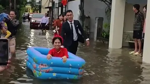 Màn rước dâu đặc biệt gây 'bão' MXH: Cô dâu cười rạng rỡ trong bể bơi phao vượt qua đoạn đường ngập lũ