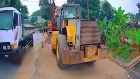 Clip: Va chạm khó hiểu khi ô tô đi vào đường công trình bị xe lu lùi trúng