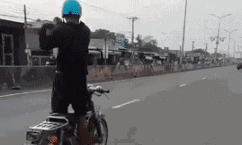 Người đàn ông đi xe máy giữa quốc lộ nhưng có hành động 'kỳ lạ' trên xe khiến ai nấy đều hoảng hồn