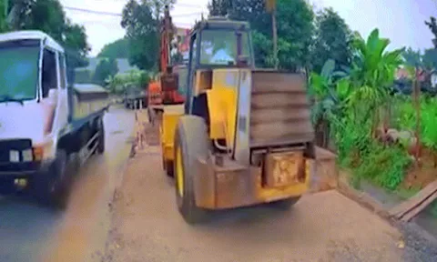 Clip: Va chạm khó hiểu khi ô tô đi vào đường công trình bị xe lu lùi trúng