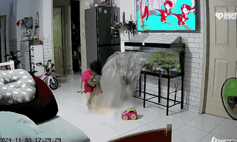 Bé gái đang chơi cạnh bể cá bỗng nước ào ào, camera ghi lại sự cố khó tin