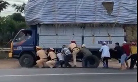CLIP: CSGT và gần 10 người đàn ông còng lưng cứu xe tải quá khổ