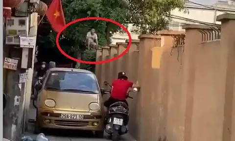 Xe máy và ô tô quyết không nhường đường, bao phương tiện dừng chờ, người dân leo lên tường để 'hóng'
