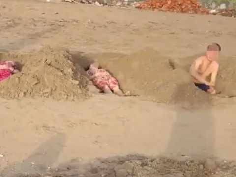 Lạ lùng chuyện nhóm du khách đào hố giống như huyệt mộ để nằm tắm cát