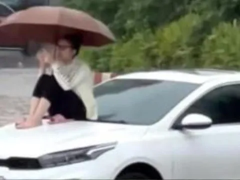 Ô tô chôn chân giữa biển nước, cô gái leo lên nóc capo ngồi ngắm cảnh