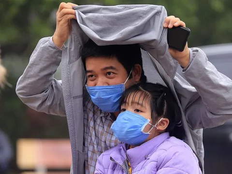 Phụ huynh trường tiểu học nơi có ca nhiễm đội mưa đưa con đi xét nghiệm COVID-19