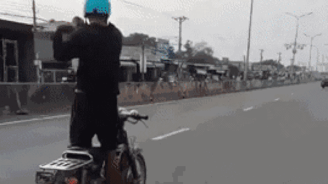 Người đàn ông đi xe máy giữa quốc lộ nhưng có hành động 'kỳ lạ' trên xe khiến ai nấy đều hoảng hồn