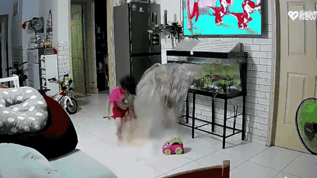 Bé gái đang chơi cạnh bể cá bỗng nước ào ào, camera ghi lại sự cố khó tin